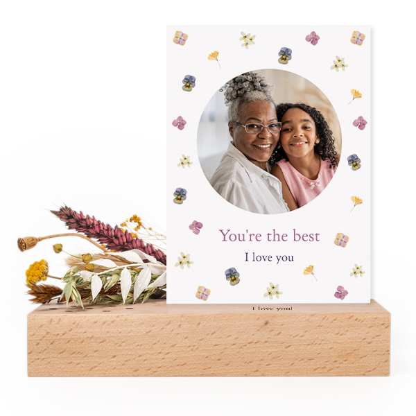 Wooden block with print, dried flowers and forex card