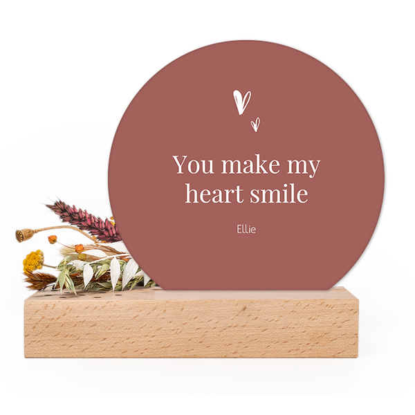 Wooden block with dried flowers and round forex card