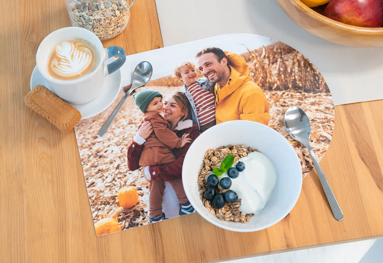 Customised plastic placemat with a family photo print, set on a wooden table.