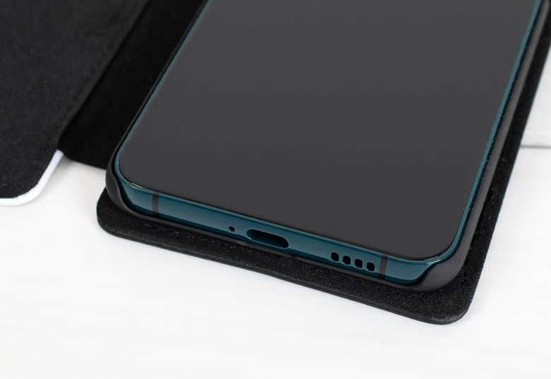 Coque portefeuille Samsung noire, ouverte, montrant un gros plan d'un téléphone et comment il s'insère dans la coque portefeuille.