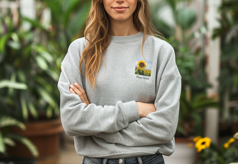 Grå personlig sweatshirt med et solsikke design og 'Plant Mom' tekst på brystet.
